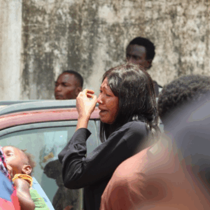 A woman cries amid a police crackdown on protesters, with tear gas filling the air and several people collapsing nearby
