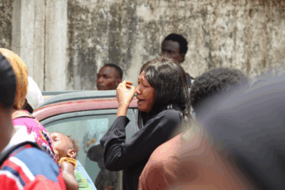 A woman cries amid a police crackdown on protesters, with tear gas filling the air and several people collapsing nearby