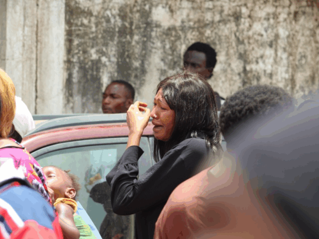 A woman cries amid a police crackdown on protesters, with tear gas filling the air and several people collapsing nearby